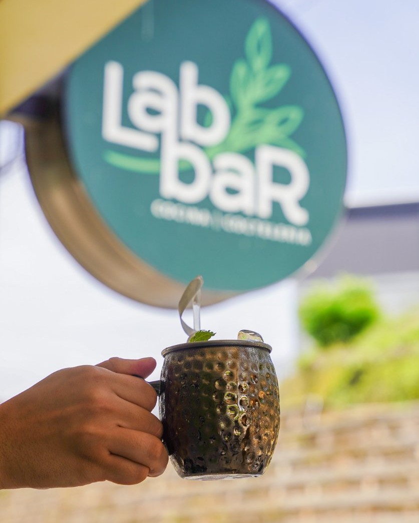 Cóctel frente al rótulo de LabBar