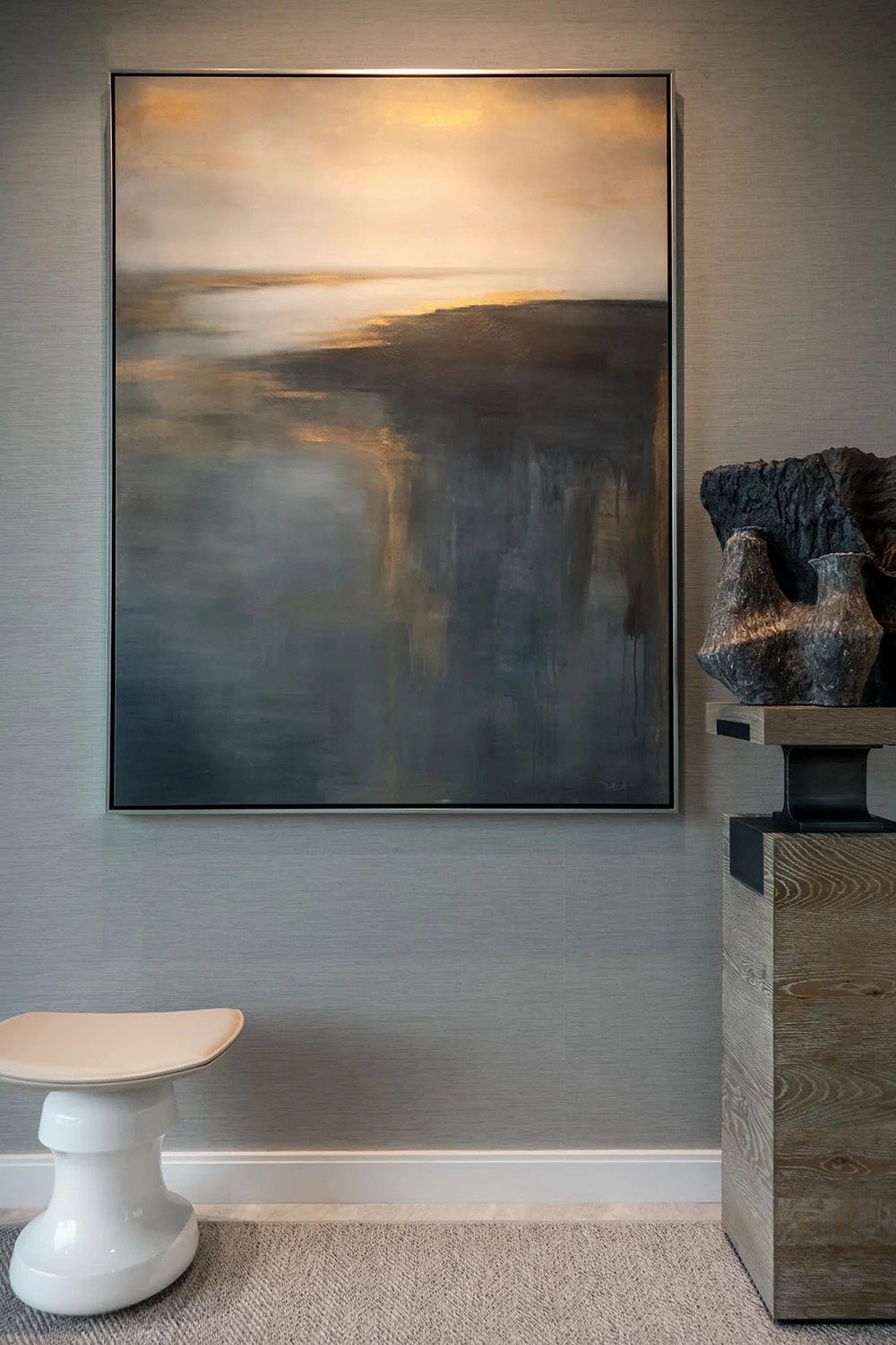 Pared de galería con arte abstracto y escultura
